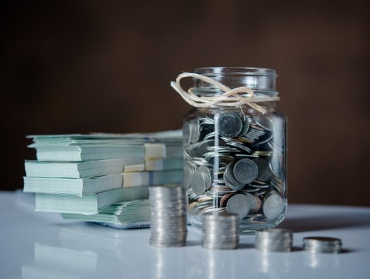 Bottles of cash with coins  in saving money concept